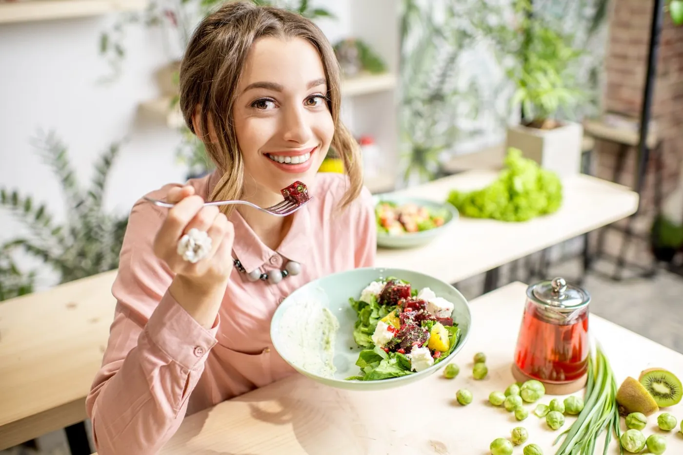 Mulher comendo salada verde fresca com prazer