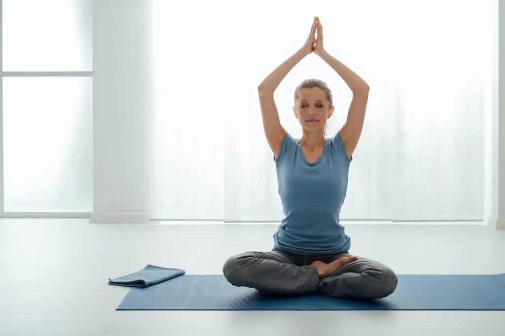 Mulher praticando yoga em casa